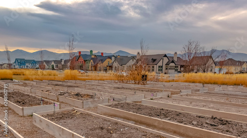 Clear Panorama Raised garden beds with homes and mountain against cloudy sky in the background