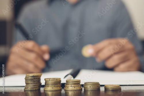 Saving money. businessman hand putting stack coins to show concept of growing savings money finance business and wealthy. blackamoor people. Leave space for writing text.