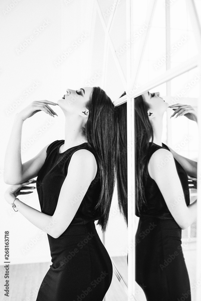 Naklejka premium Sensual brunette in the room near the window. Black and white