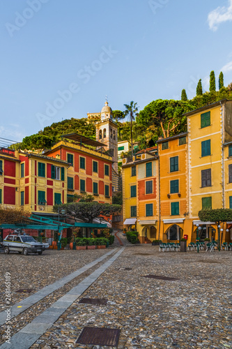 Colorful houses of the Piazzetta square and empty outdoor cafe in the coastal italian village Portofino in Liguria region, Italy