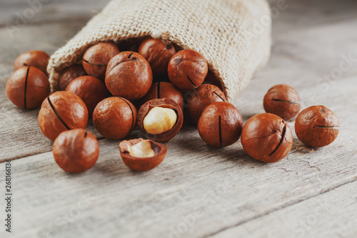 Macadamia nut on a wooden table in a bag, closeup, top view photo