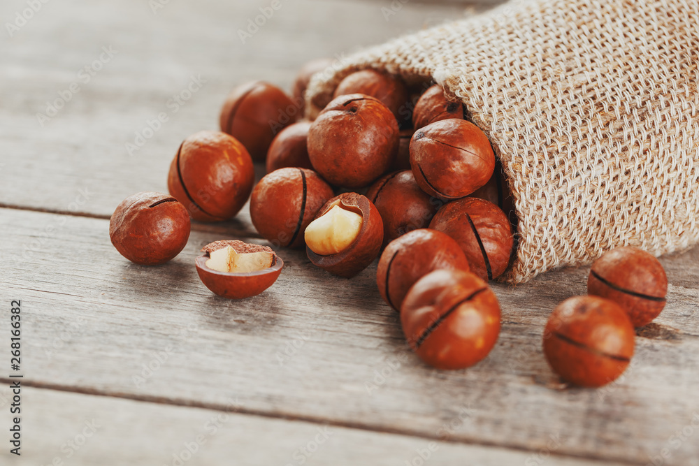 Macadamia nut on a wooden table in a bag, closeup, top view Macadamia nut on a wooden table in a bag, closeup, top view