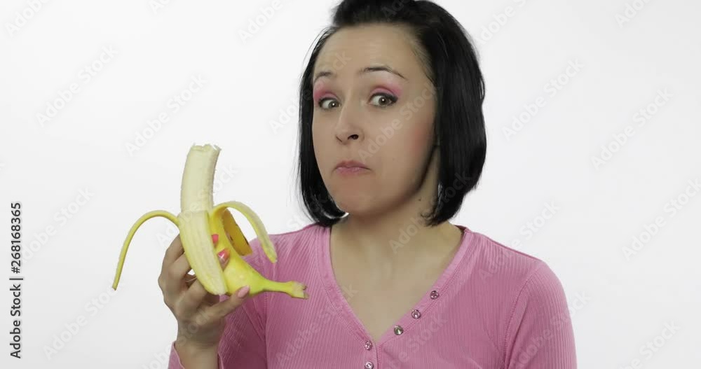 Young beautiful woman eating big, fresh banana on white background Young beautiful woman eating big, fresh banana on white background