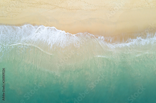 Aerial view of turquoise ocean wave reaching the coastline. Beautiful tropical beach from top view. Andaman sea in Thailand. Summer holiday vacation concept photo