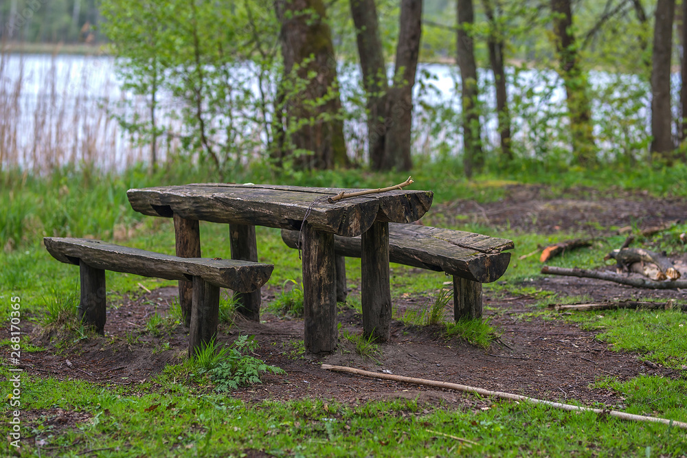 wooden table with bench by the lake in the forest wooden table with bench by the lake in the forest