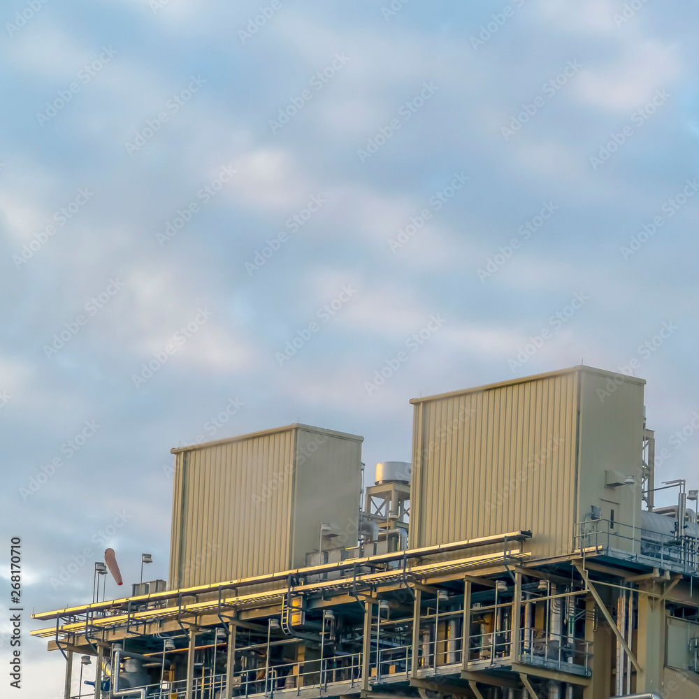 Clear Square Cloudy blue sky viewed behind the towers and buildings of a Power Plant Clear Square Cloudy blue sky viewed behind the towers and buildings of a Power Plant