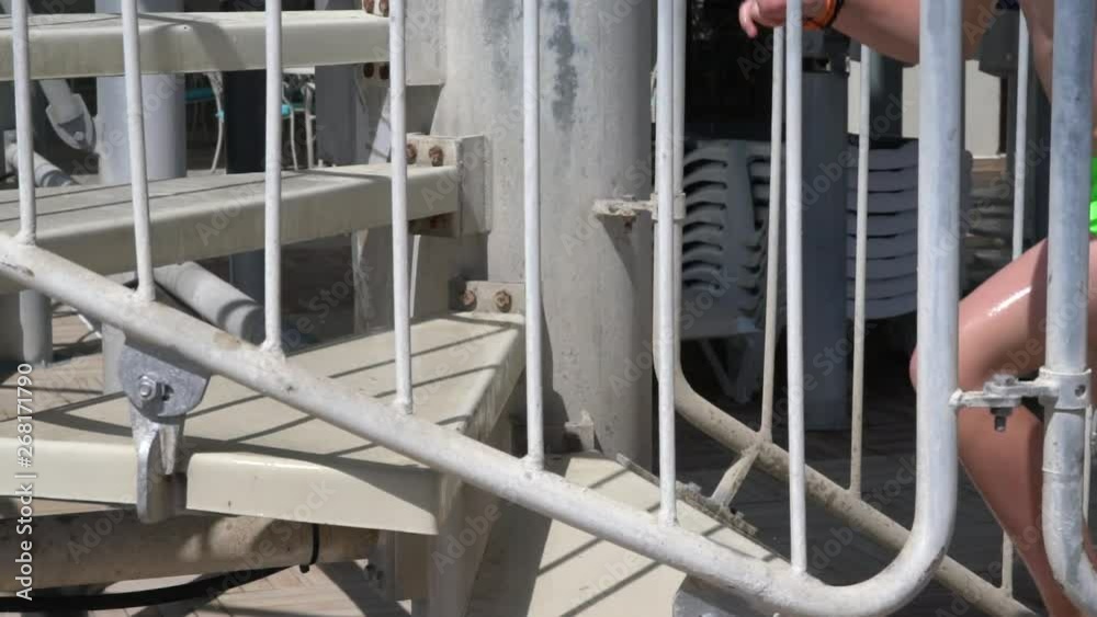 Young barefoot man in bright green trunks