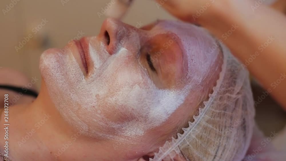 woman receiving facial massage at beauty salon. Woman getting a cosmetic treatment, close-up. Beautician hands at work, applying facial mask on a beautiful face woman receiving facial massage at beauty salon. Woman getting a cosmetic treatment, close-up. Beautician hands at work, applying facial mask on a beautiful face