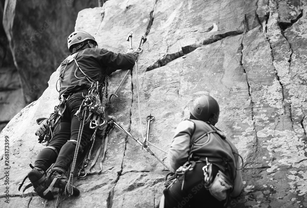Rock climbers on a rock wall closeup. Climbing gear and equipment