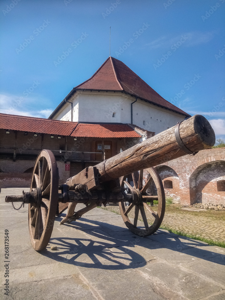 Canon in the citadel of Targu Mures, Romania with a tower of the ancient castle in the background