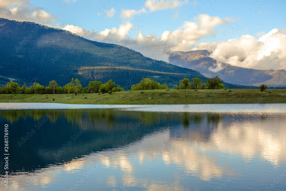 Mountain forest lake reflection, spring and travel time.