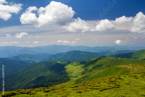 Green mountains panorama under blue sky on bright sunny day. Tourism and traveling concept, copy space background. © bilanol