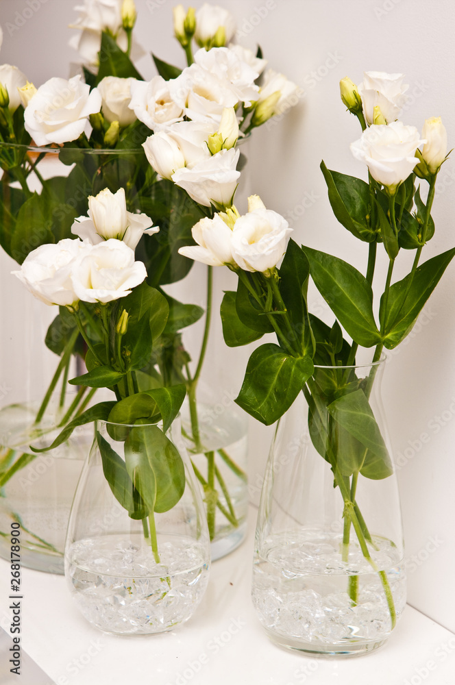 White eustoma flowers in glass on white background