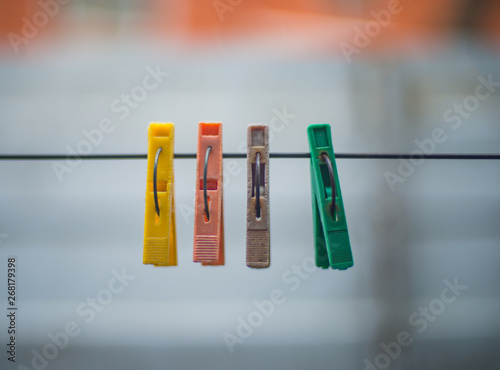old colored clothespins hanging on a wire for drying clothes. Clothespins on blurred background