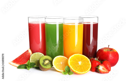 Glasses with different juices and fresh fruits on white background photo