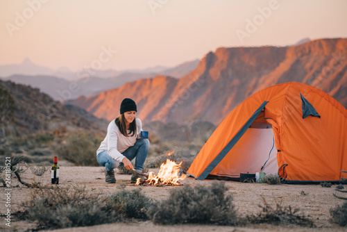 hiker camping in a desert wilderness by a campfire photo