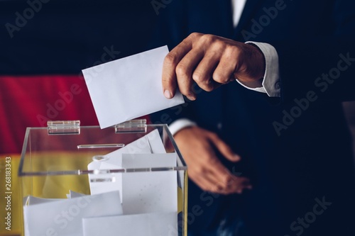 Elections in Germany. Man throwing his vote into the ballot box. photo