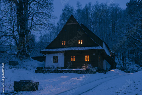 Traditional log cabin in snow covered landscape photo