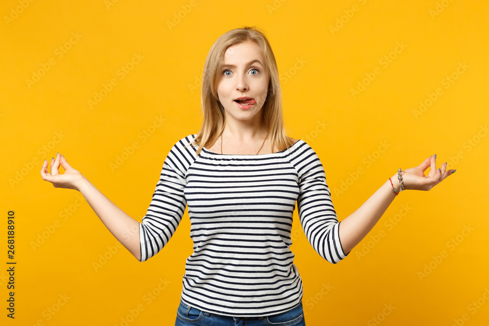 Beautiful young blonde woman in striped clothes hold hands in yoga gesture isolated on bright yellow orange background, studio portrait. People sincere emotions lifestyle concept. Mock up copy space. Beautiful young blonde woman in striped clothes hold hands in yoga gesture isolated on bright yellow orange background, studio portrait. People sincere emotions lifestyle concept. Mock up copy space.