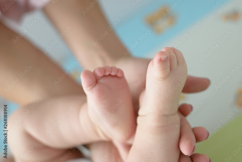Mother's hand holding gently tiny Caucasian baby feet and toes, concept for families and generations, care for infants and newborn in early stages of their life, mother's love or population growth Mother's hand holding gently tiny Caucasian baby feet and toes, concept for families and generations, care for infants and newborn in early stages of their life, mother's love or population growth
