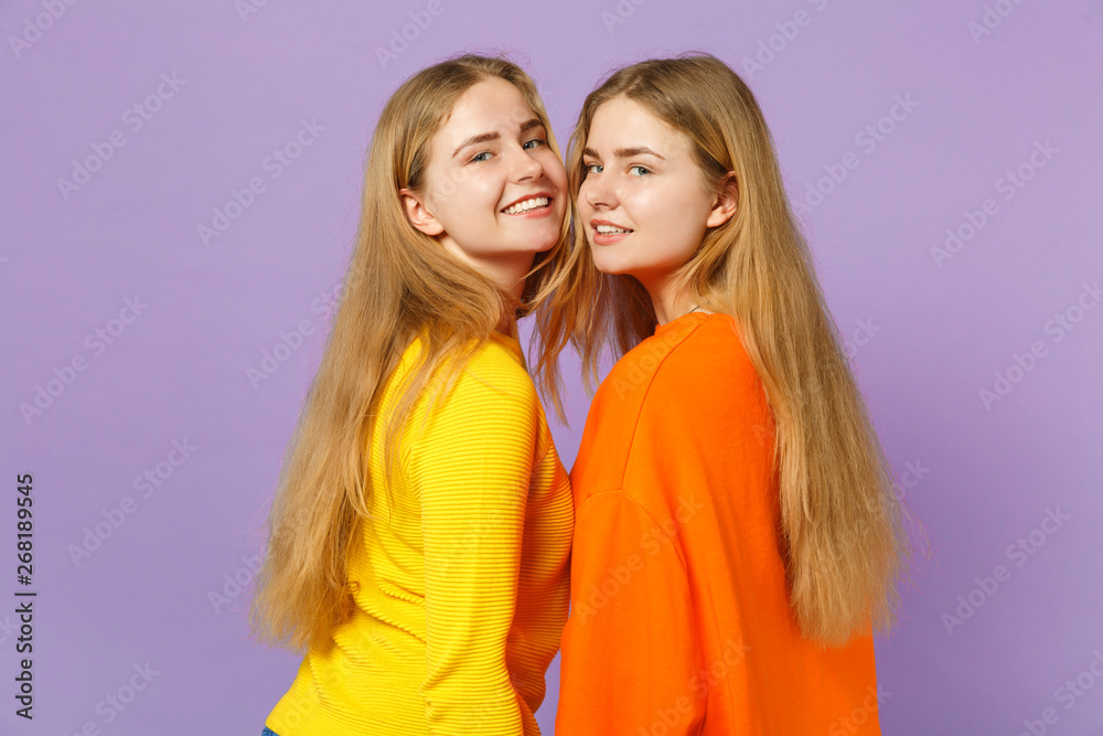 Side view of two attractive young blonde twins sisters girls in Side view of two attractive young blonde twins sisters girls in