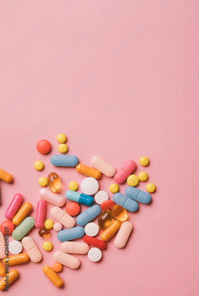 Colourfull pills on pink backround