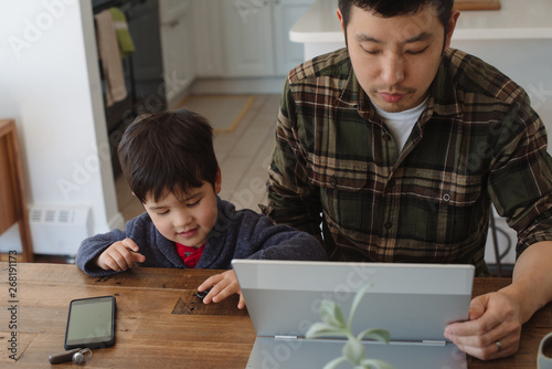 Dad working from home with son nearby photo