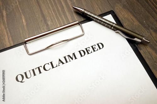 Clipboard with quitclaim deed on desk