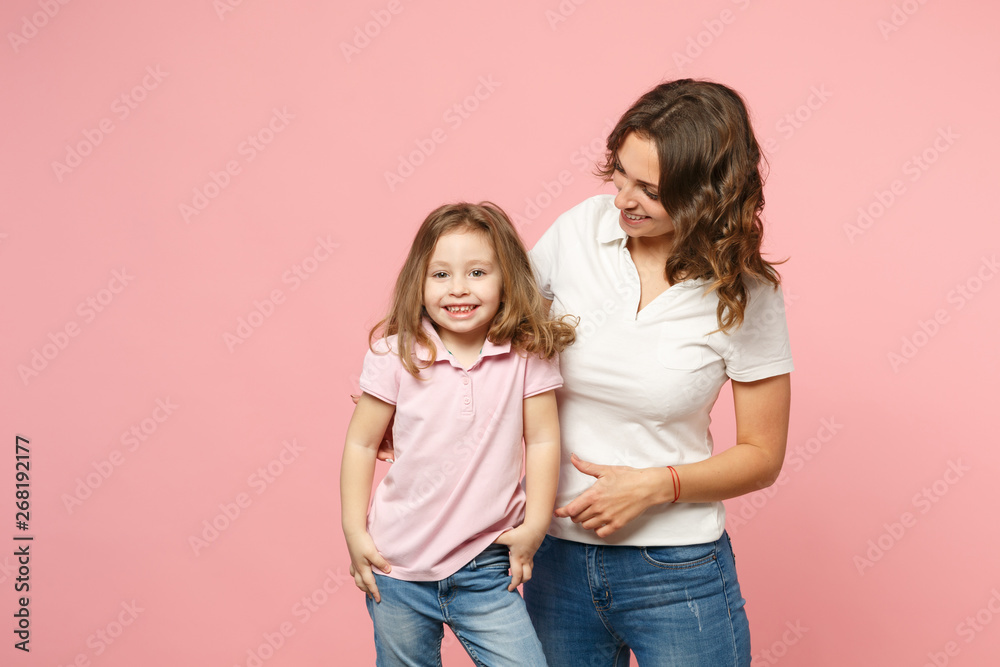 Woman in light clothes have fun with cute child baby girl. Mother, little kid daughter isolated on pastel pink wall background, studio portrait. Mother's Day, love family, parenthood childhood concept