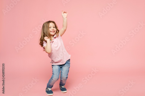 Little cute child kid baby girl 3-4 years old wearing light clothes dancing isolated on pastel pink wall background, children studio portrait. Mother's Day, love family, parenthood childhood concept.