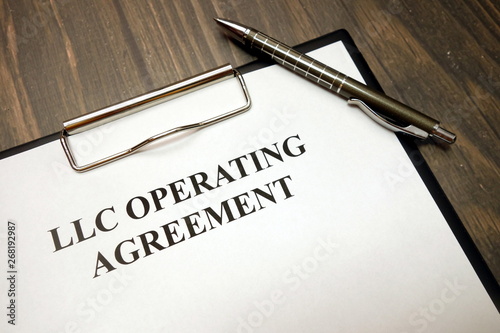 Clipboard with llc operating agreement and pen on desk photo