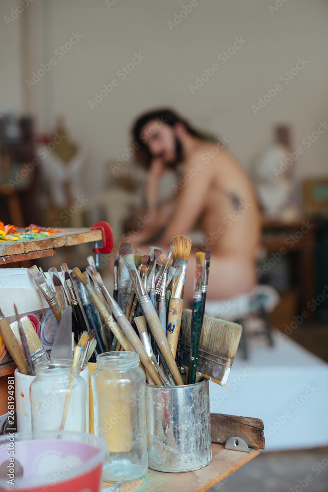 Artist woman drawing a model in her studio. Artist woman drawing a model in her studio.