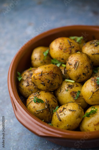 Baked potatoes with herbs in bowl