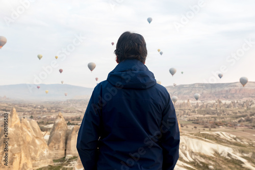 Man looking at flying air balloons