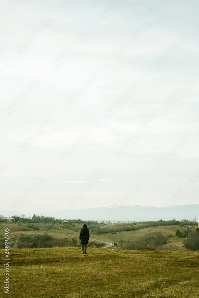 Young man walks on the hillside