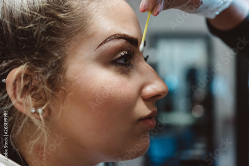 A young woman having her eyebrows micro bladed photo