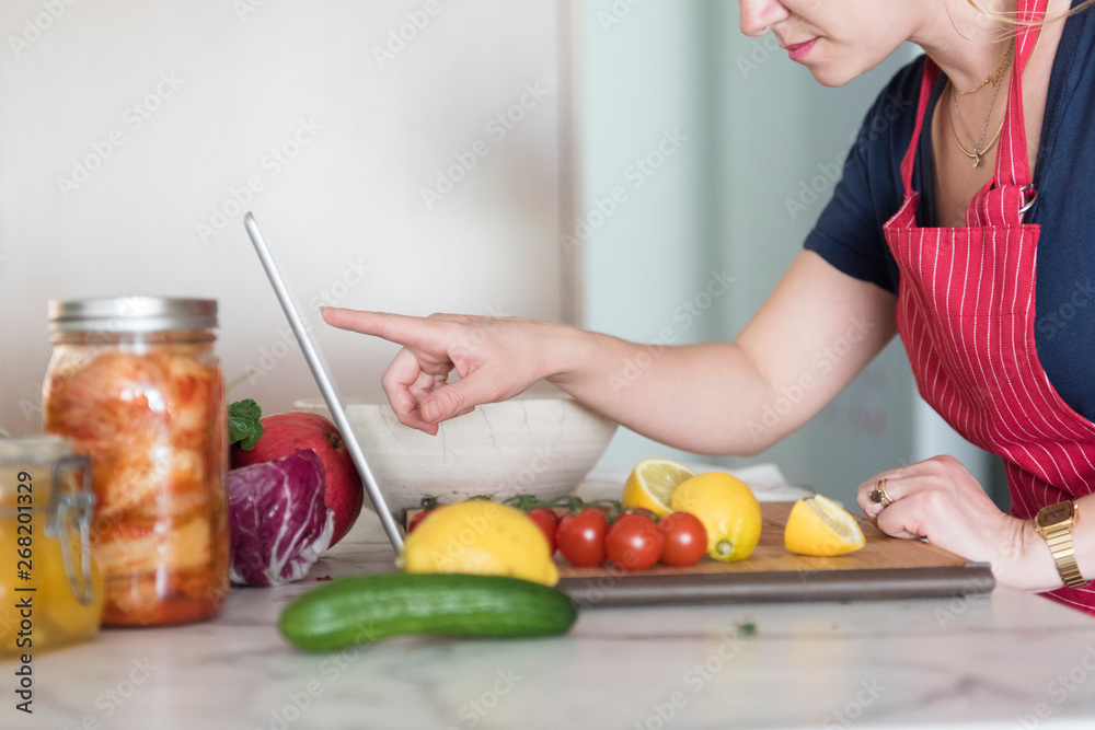 Chef consulting laptop next to ingredients Chef consulting laptop next to ingredients