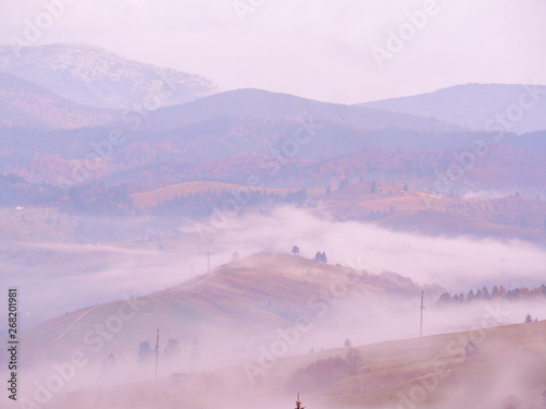 Carpatian village at mountains at the sunny foggy day photo