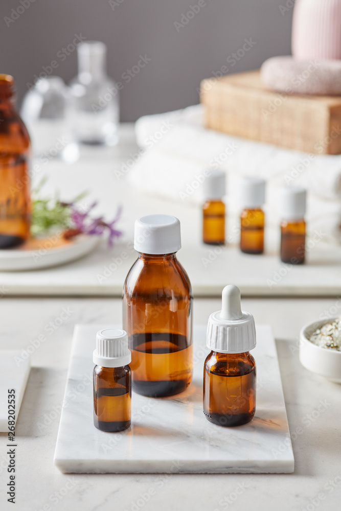 Essential oils in brown glass bottles of different size.