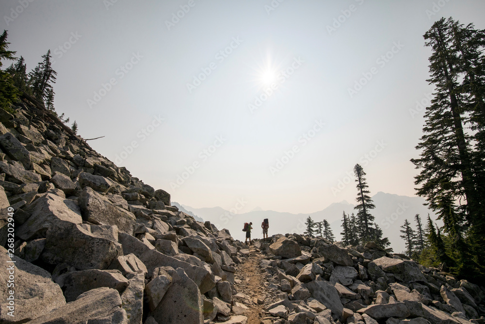 Two young men hiking on the top of a mountain in the Cascade range. Two young men hiking on the top of a mountain in the Cascade range.