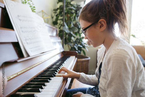 Cute girl practicing piano at home