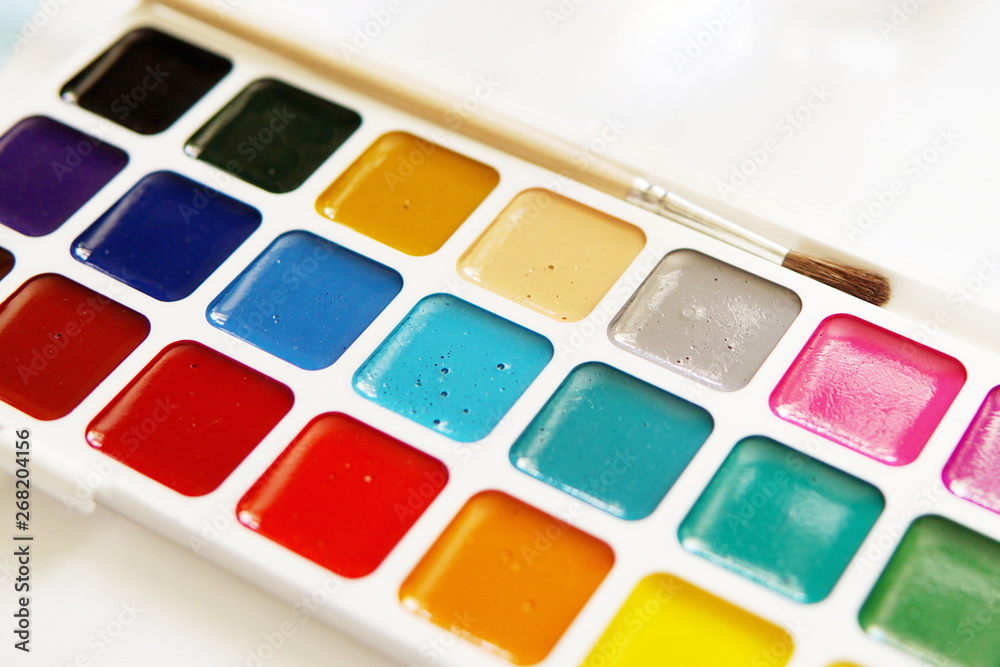 Tools of an watercolor artist-painter. White background, new beautiful paints and brashes. Close up. Tools of an watercolor artist-painter. White background, new beautiful paints and brashes. Close up.