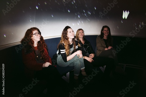 Tour group looking up in planetarium photo