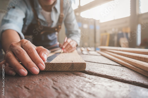 Billede på lærred Carpenter working with equipment on wooden table in carpentry shop