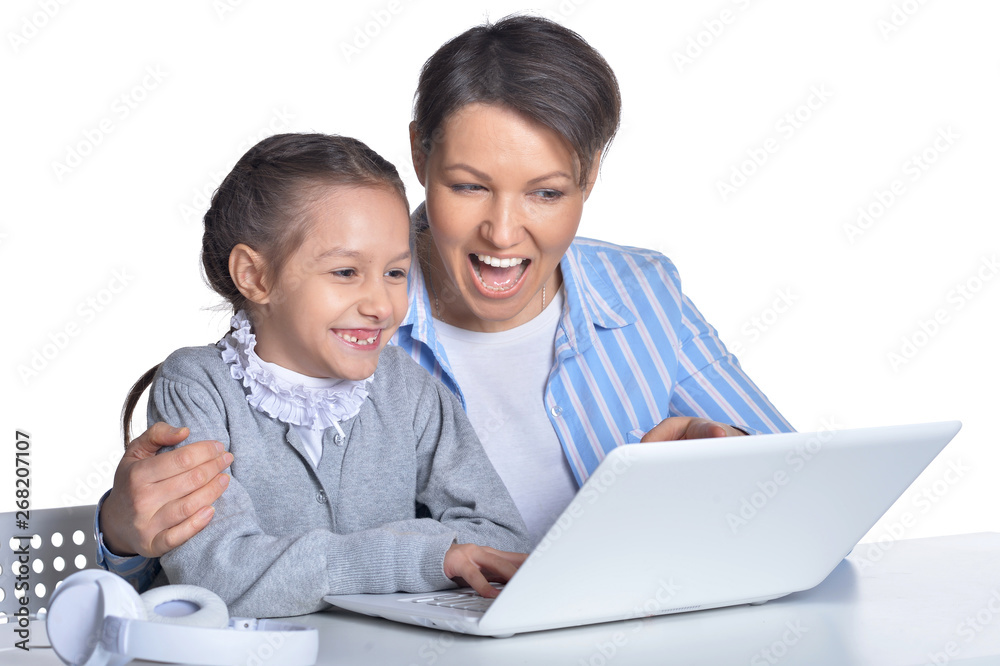 Happy mother and daughter using laptop isolated on white background Happy mother and daughter using laptop isolated on white background