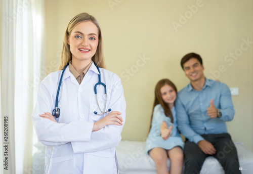 Beautiful smiling doctor woman looking  at camera in working environment on background of patient,Concept of a health care.