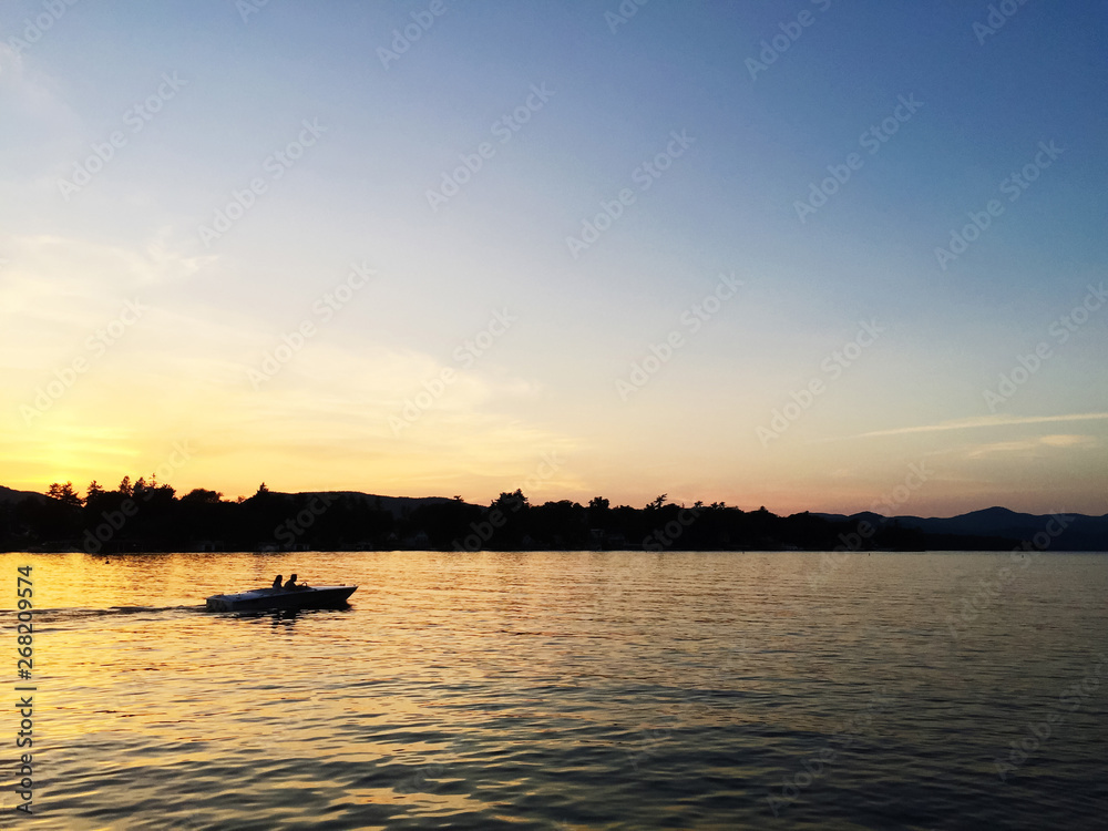 A couple goes for a boat ride at sunset A couple goes for a boat ride at sunset