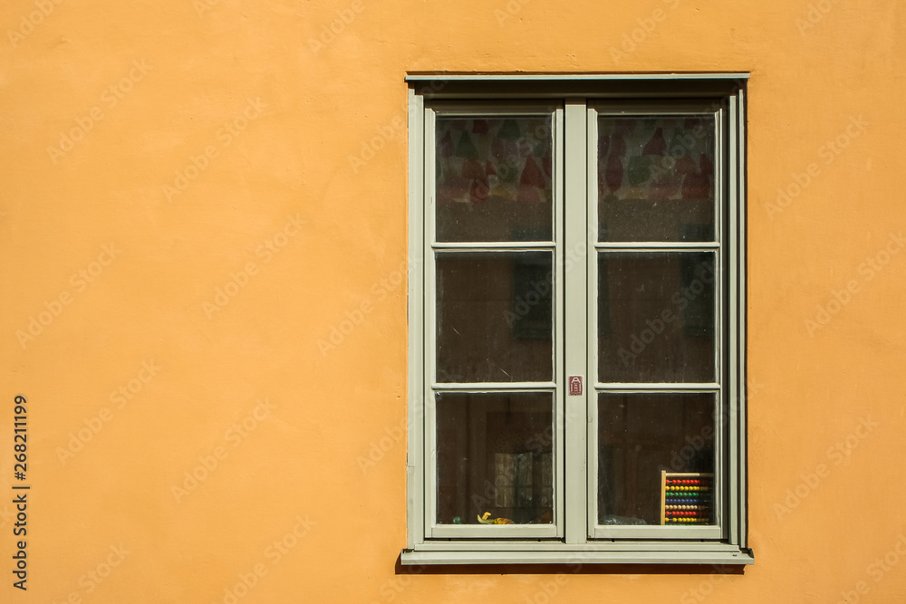 One white window on a yellow facade of the nordic house in Sweden. One white window on a yellow facade of the nordic house in Sweden.
