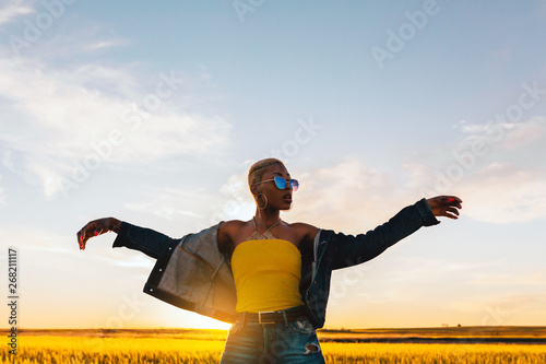 Young woman dancing in field during sunset