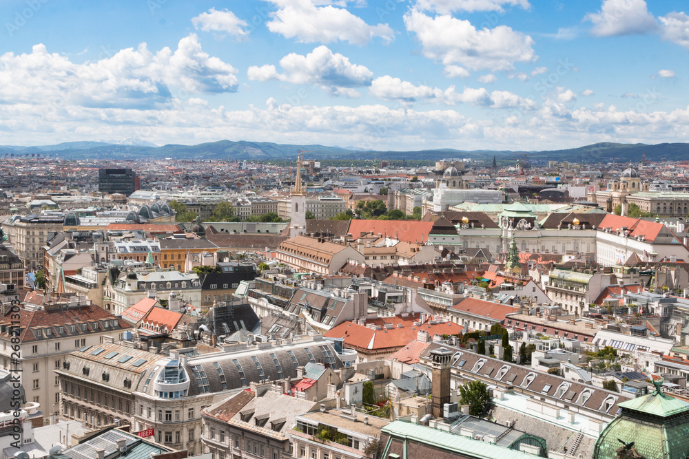 Wien, Austria. May, 2019. Panorama of the city from the observation tower of St. Stephen’s Cathedral. Roofs of houses. In the distance, the Alpine Mountains. Sky view.